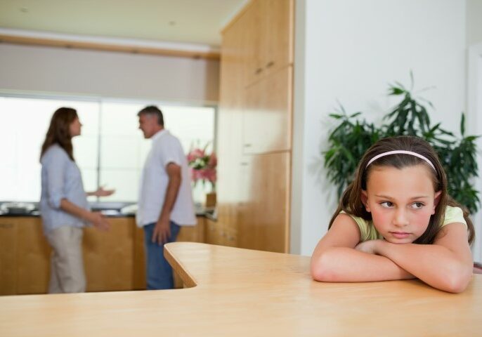A child looking sad while parents fight