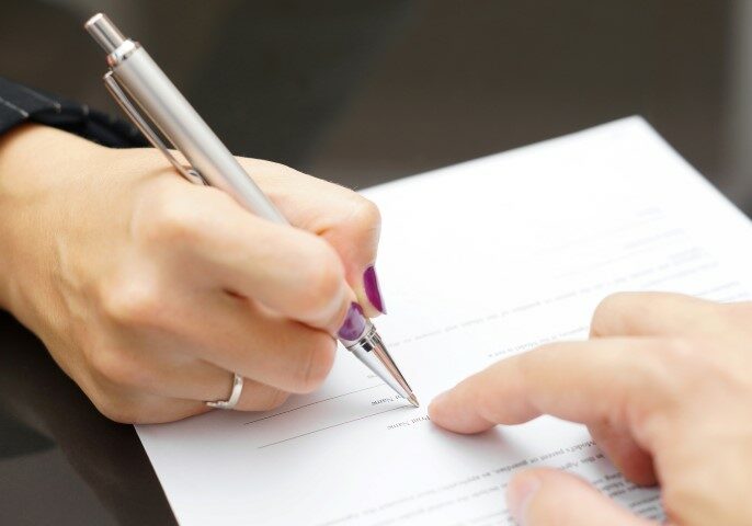 A woman signing a property division agreement